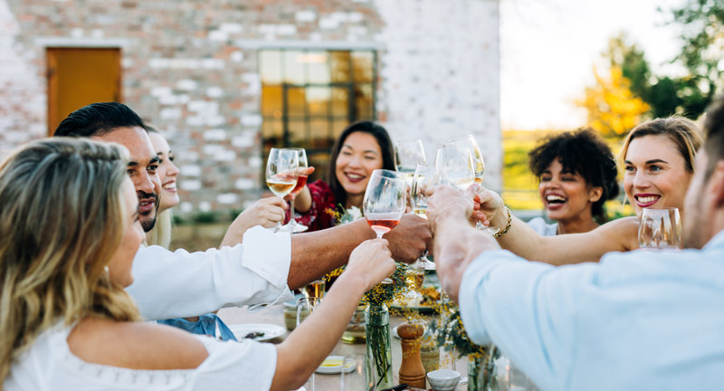 partage-a-la-table-gite-pierre-qui-roule des gens trinquent et sont heureux autour d un repas